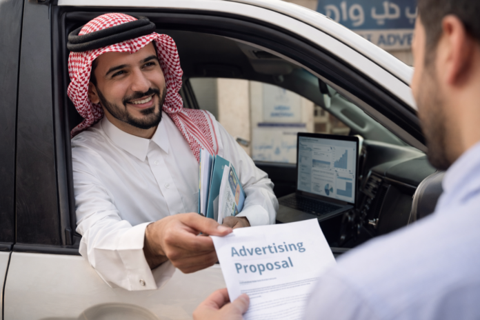 ChatGPT Image Jan 22, 2026, 02_18_06 AM مندوب مبيعات سعودي يعرض خدمات الدعاية والإعلان على أحد العملاء في الخرج ضمن عمل ميداني احترافي